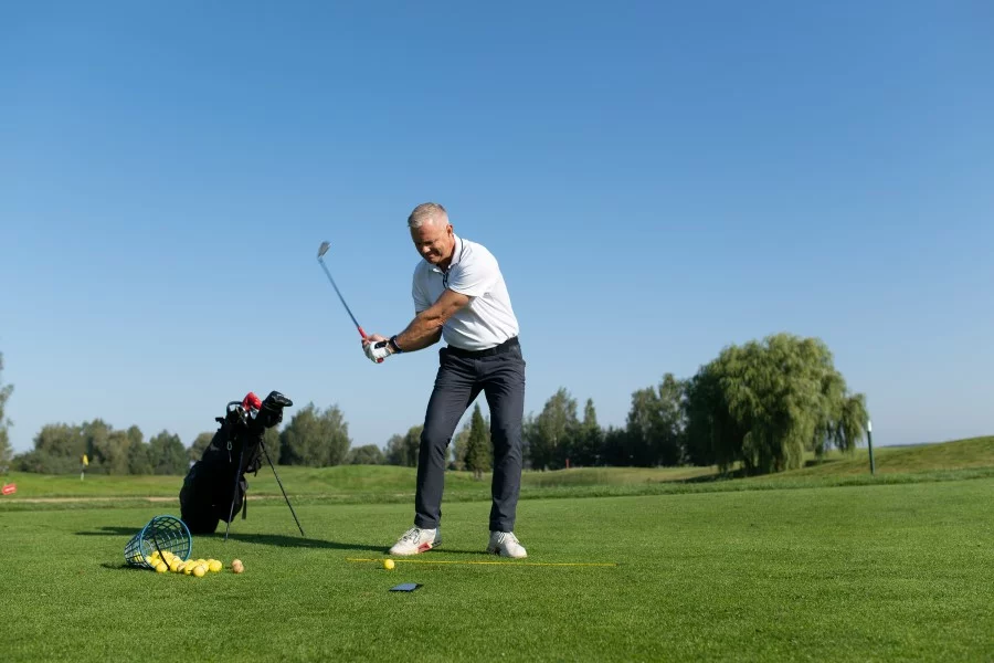 golfer-training-on-golf-course-with-bucket-of-golf-balls